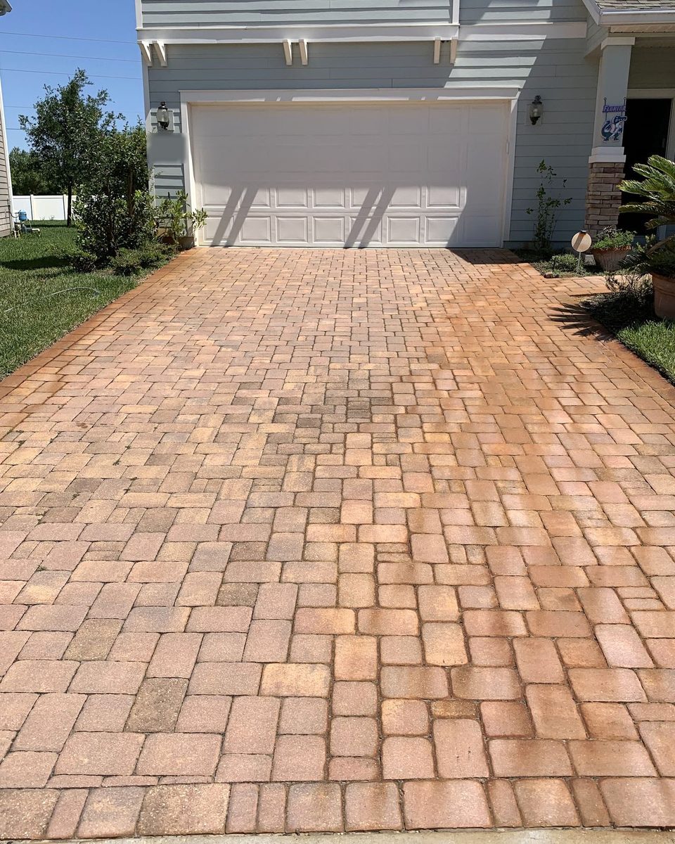 A paver driveway darkened with mildew and dirt