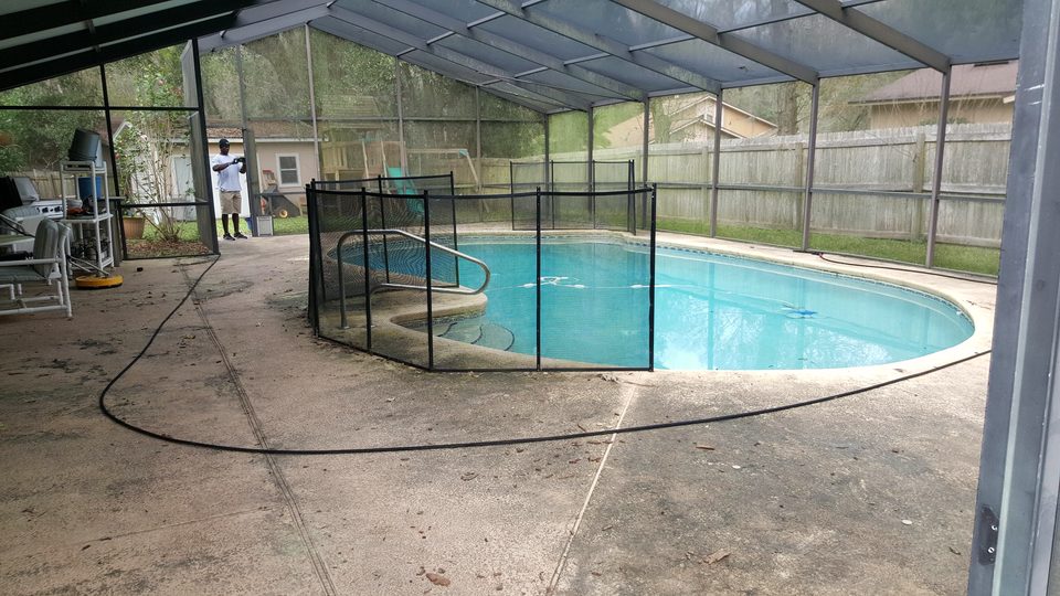 Screened pool enclosure with a clean concrete deck around the pool