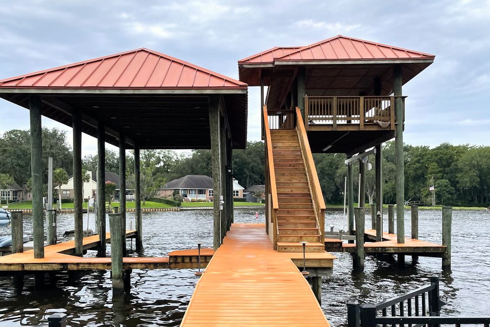 A private dock and two-story boathouse on the water, the walkway clean again